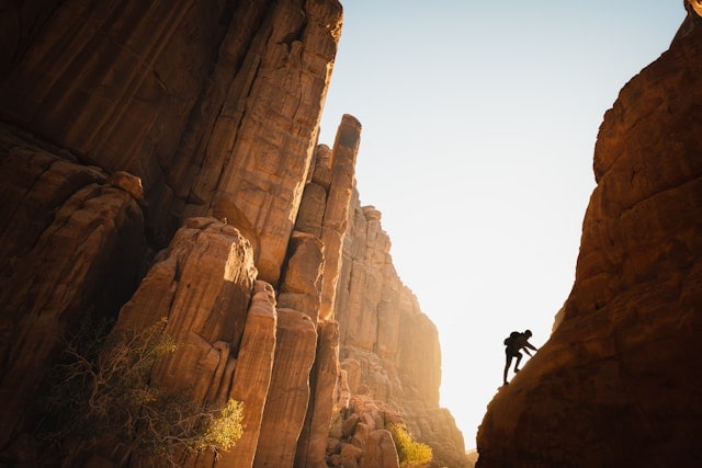 Man rock climbing in a rocky desert cliff landscape